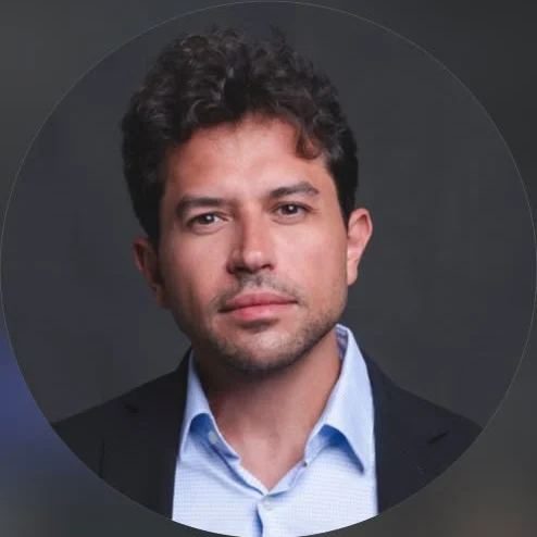 Retrato do Dr. Felipe Alcoléa, cirurgião-dentista, de blazer escuro e camisa azul-clara
